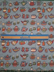 One yard cotton blend fabric features teapots on a light blue background