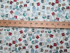 THREAD SPOOLS OF THREAD ON CREAM COTTON FABRIC FQ