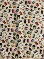 THREAD SPOOLS NEEDLES BOBBINS ON CREAM COTTON FABRIC BTHY